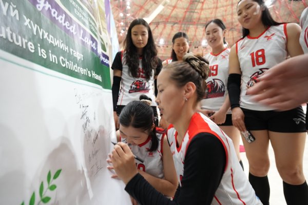 A team adds its signatures beneath the line “The Future is in Children’s Hands”.