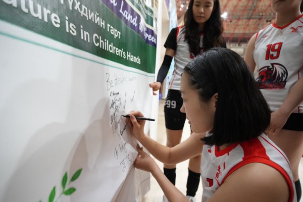 Signing under the Mongolian and English wording of the pledge.