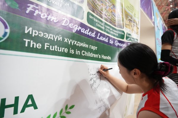 A player signs while her team looks on.