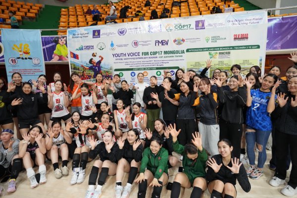 Players from clubs across the tournament assemble in front of the campaign banner.